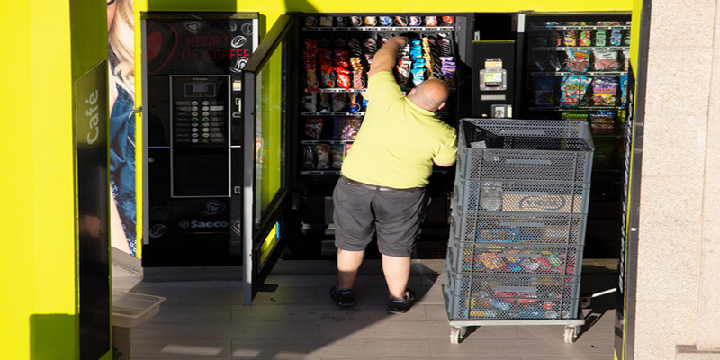 Galicia, Spain; june 25, 2021: Rear view of a Worker replenishing a vending machine